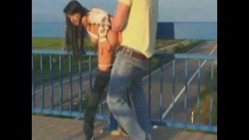 Грудастая темноволосая красотка занимается сексом со своим парнем на середине моста